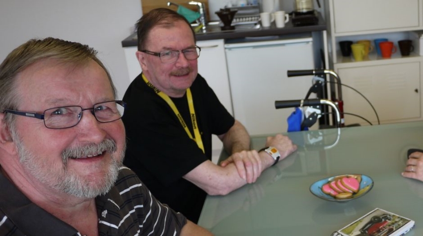 Two smiling men at a table